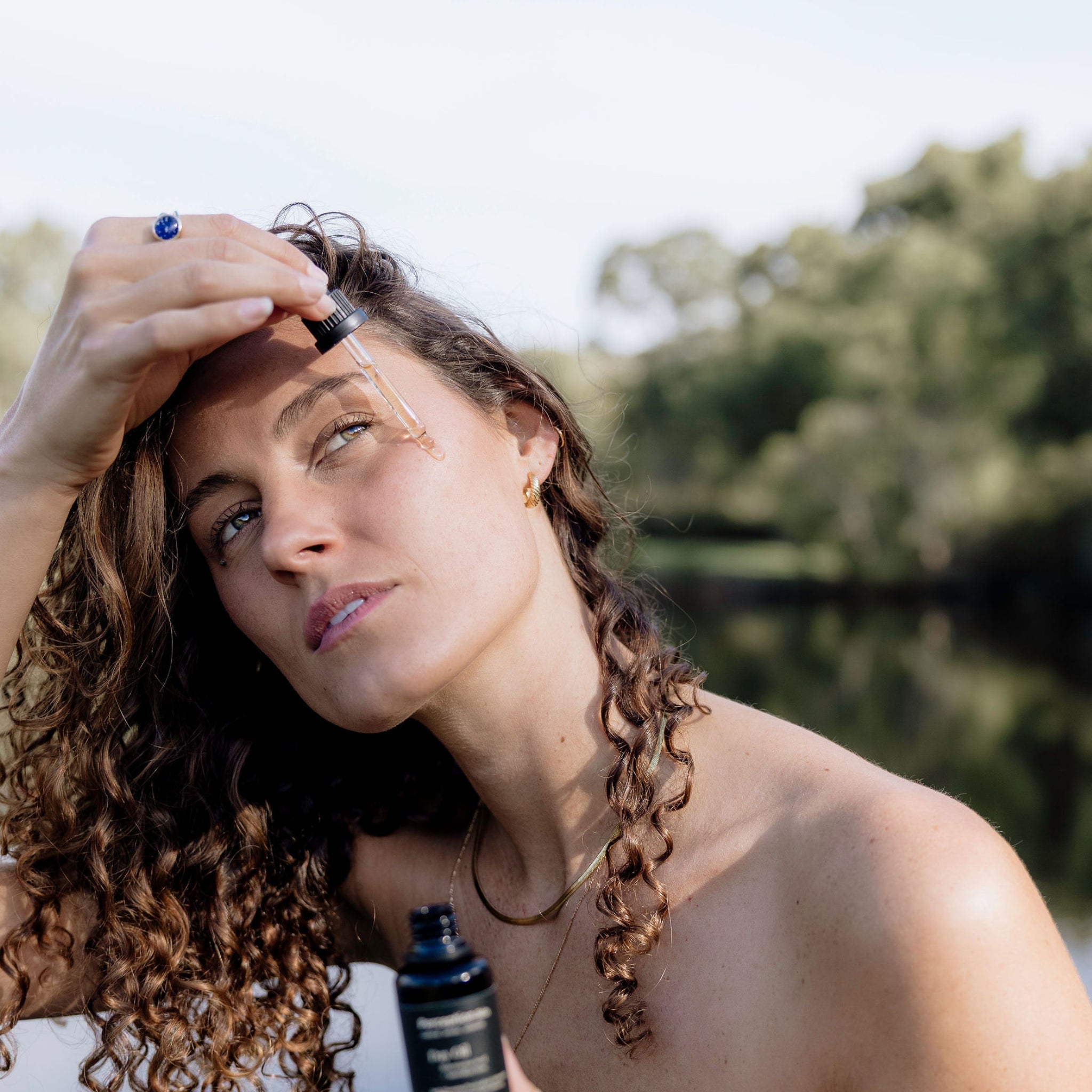 Perception Skin model dropping the award-nominated Watermelon Seed + Australian Rose Day Oil on her face, water in the background