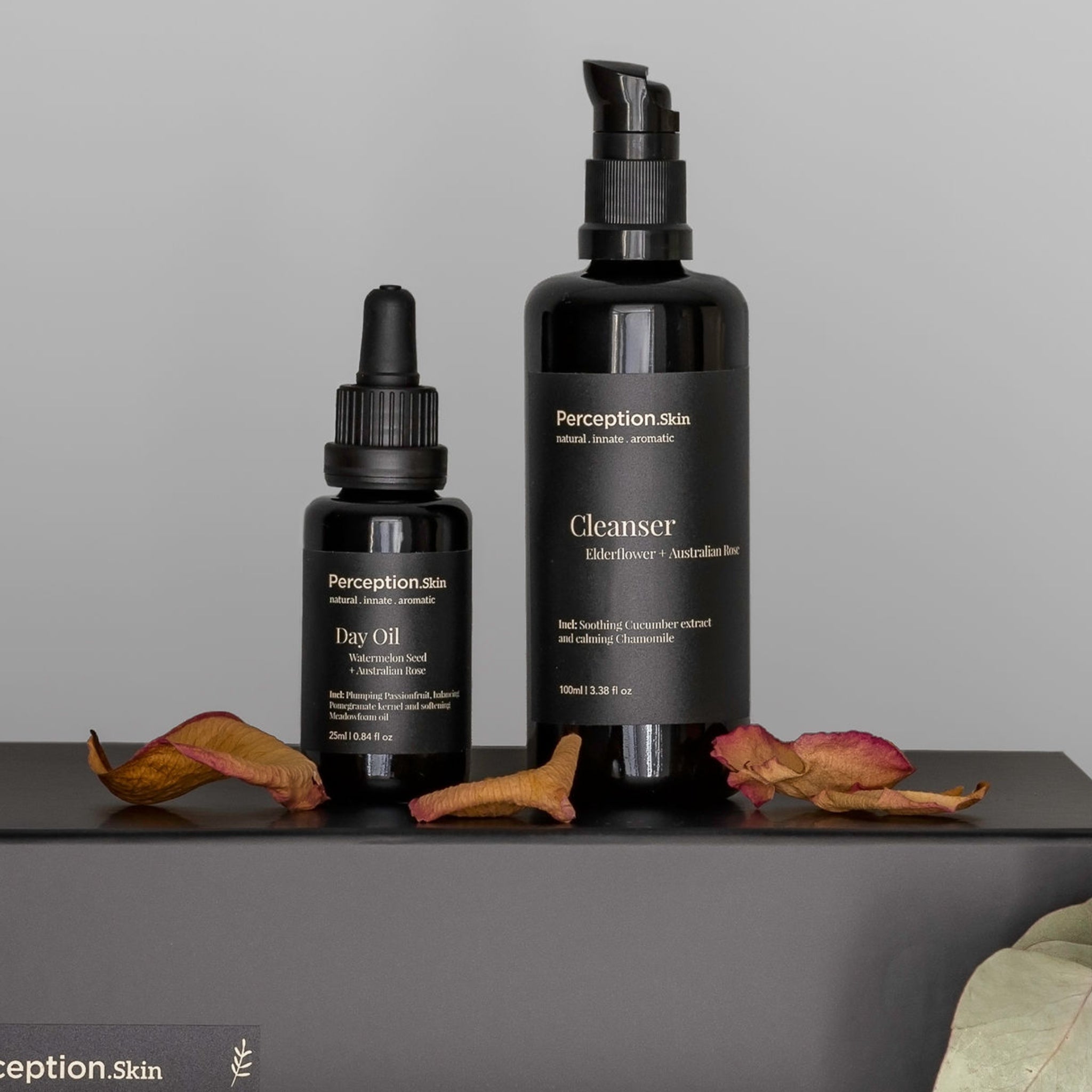 Perception Skin's Elderflower + Australian Rose and Watermelon Seed + Australian Rose Day sitting on a black box with sprinkled rose petals