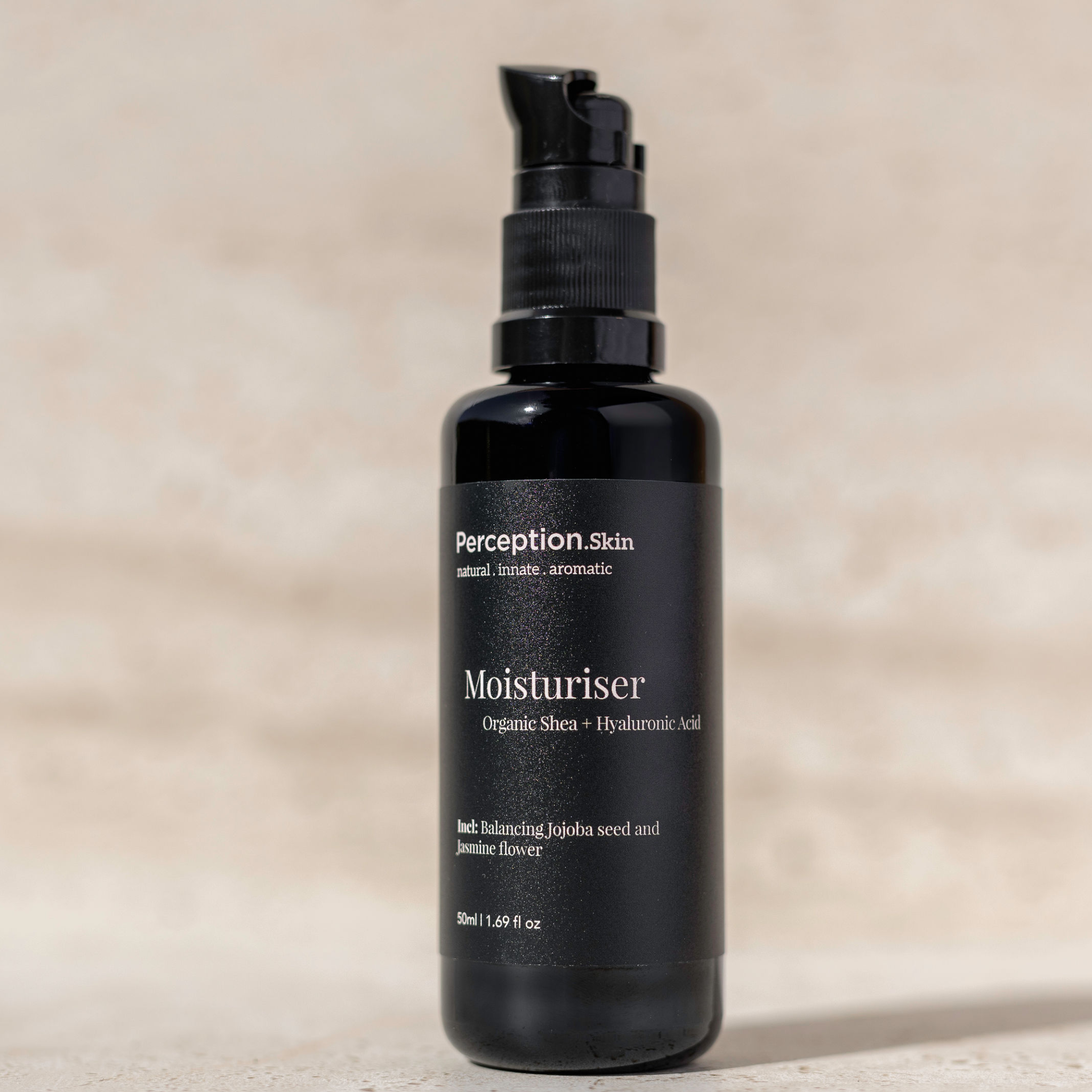 Black moisturizer bottle with 'Perception Skin' label on a beige background