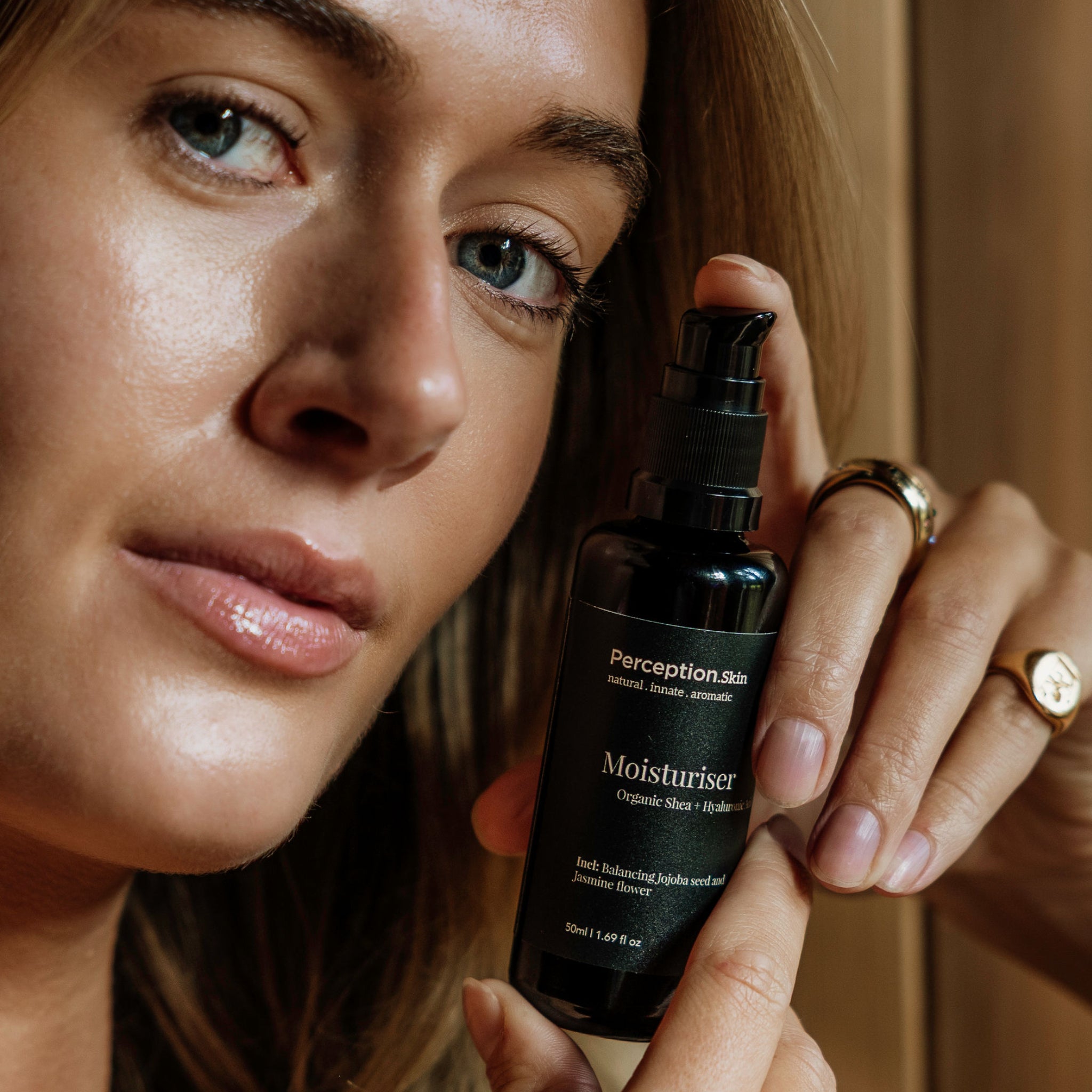 Perception Skin Organic Shea + Hyaluronic acid Moisturiser, model holding moisturiser in hands