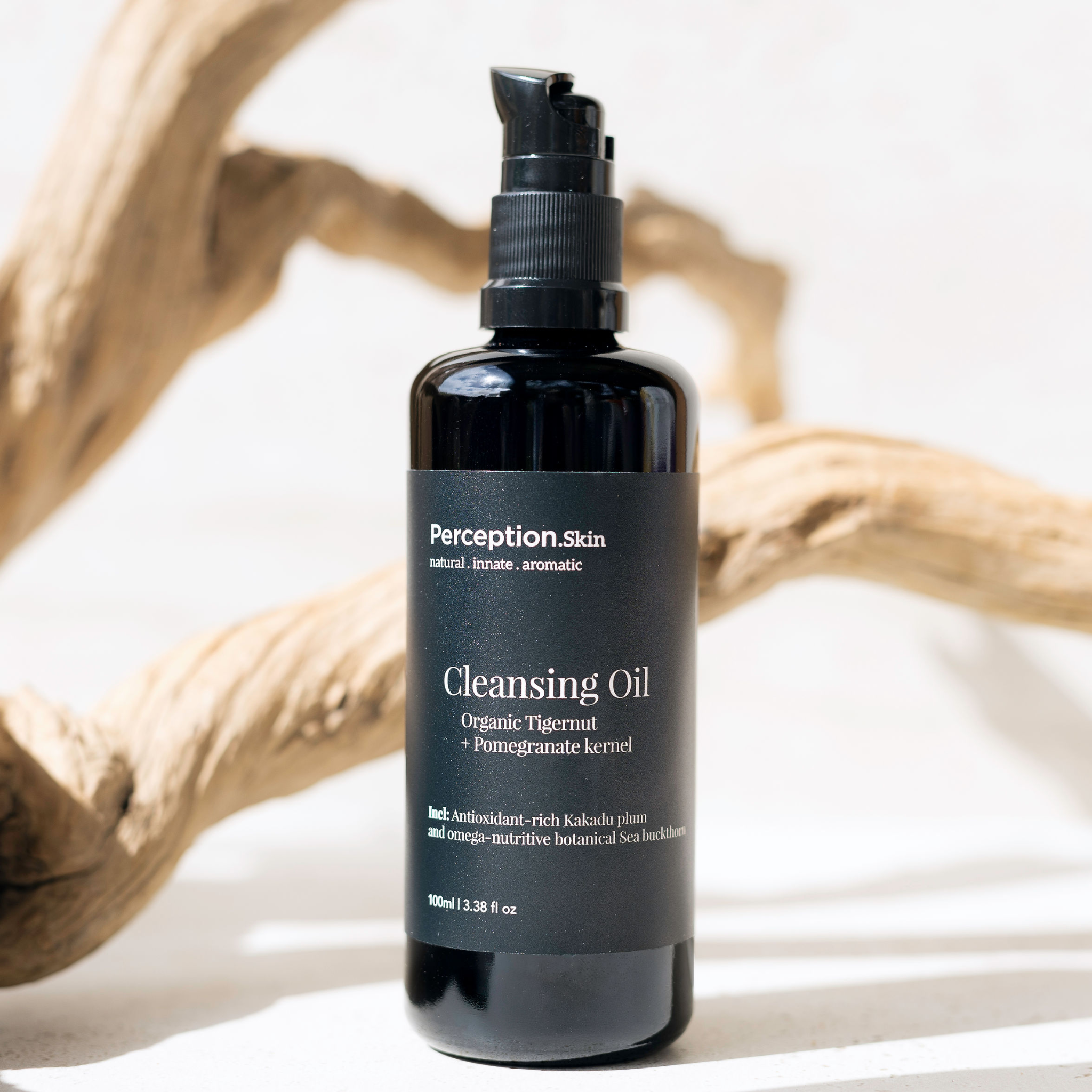Bottle of Perception Skin Cleansing Oil on a neutral background with natural elements.