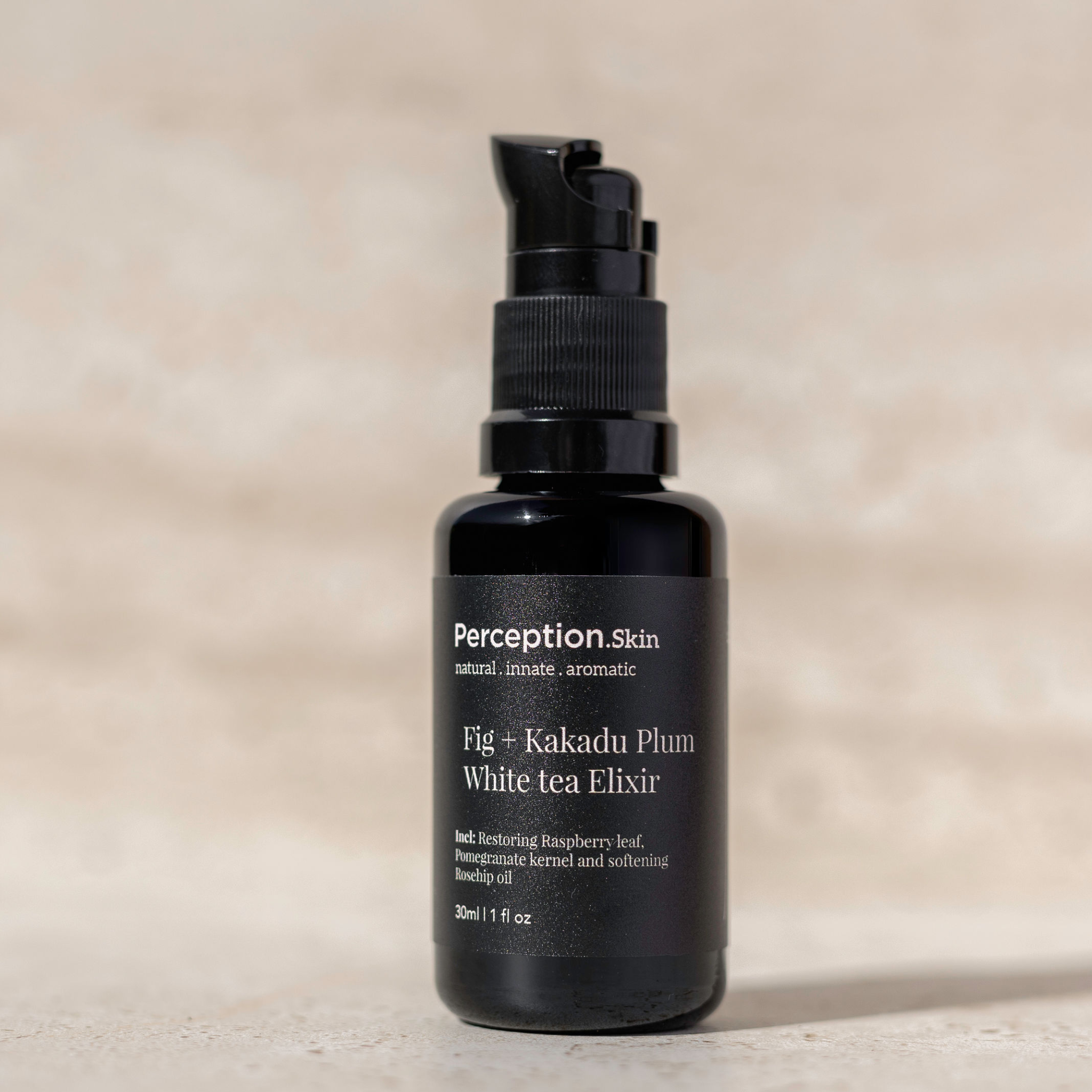 Black bottle of Perception Skin Fig + Kakadu Plum White Tea Elixir on a beige background